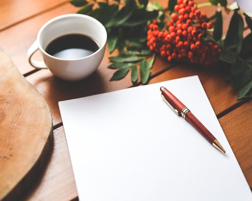 Editorial team desk with notes and coffee